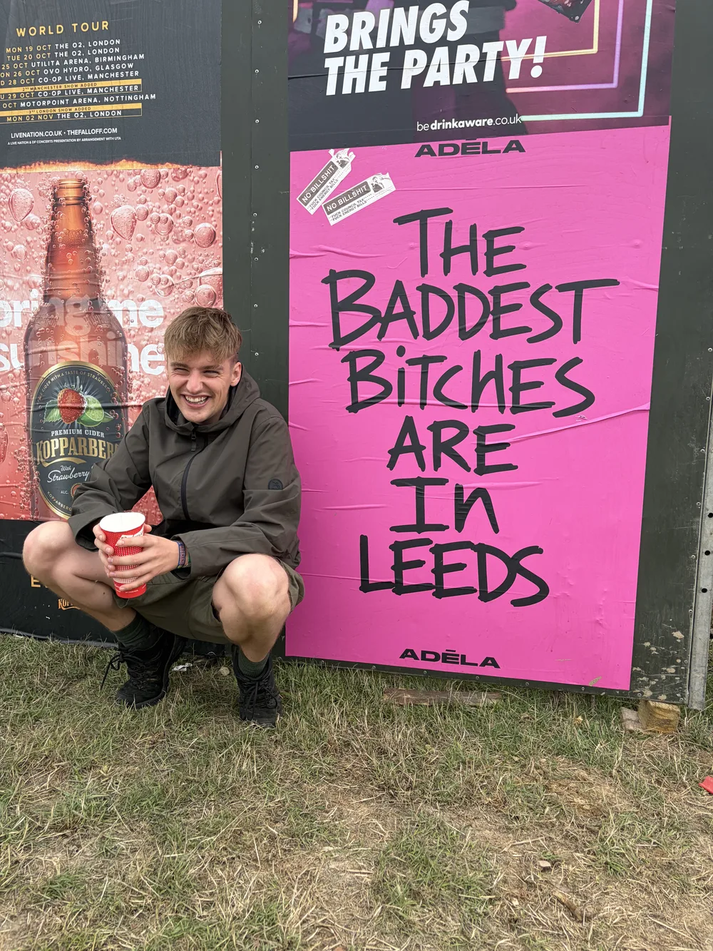Declan beside a bright pink Leeds festival poster
